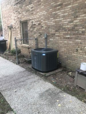 a stone building that has a bench in front of a brick wall